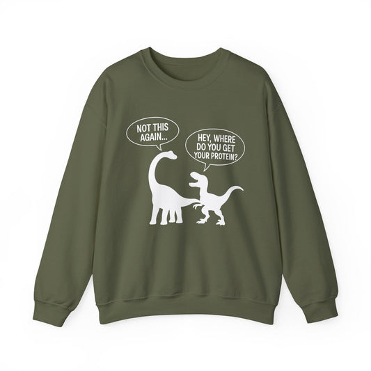 An military green crewneck sweatshirt featuring a white graphic of a sauropod and a theropod dinosaur with speech bubbles reading 'NOT THIS AGAIN.