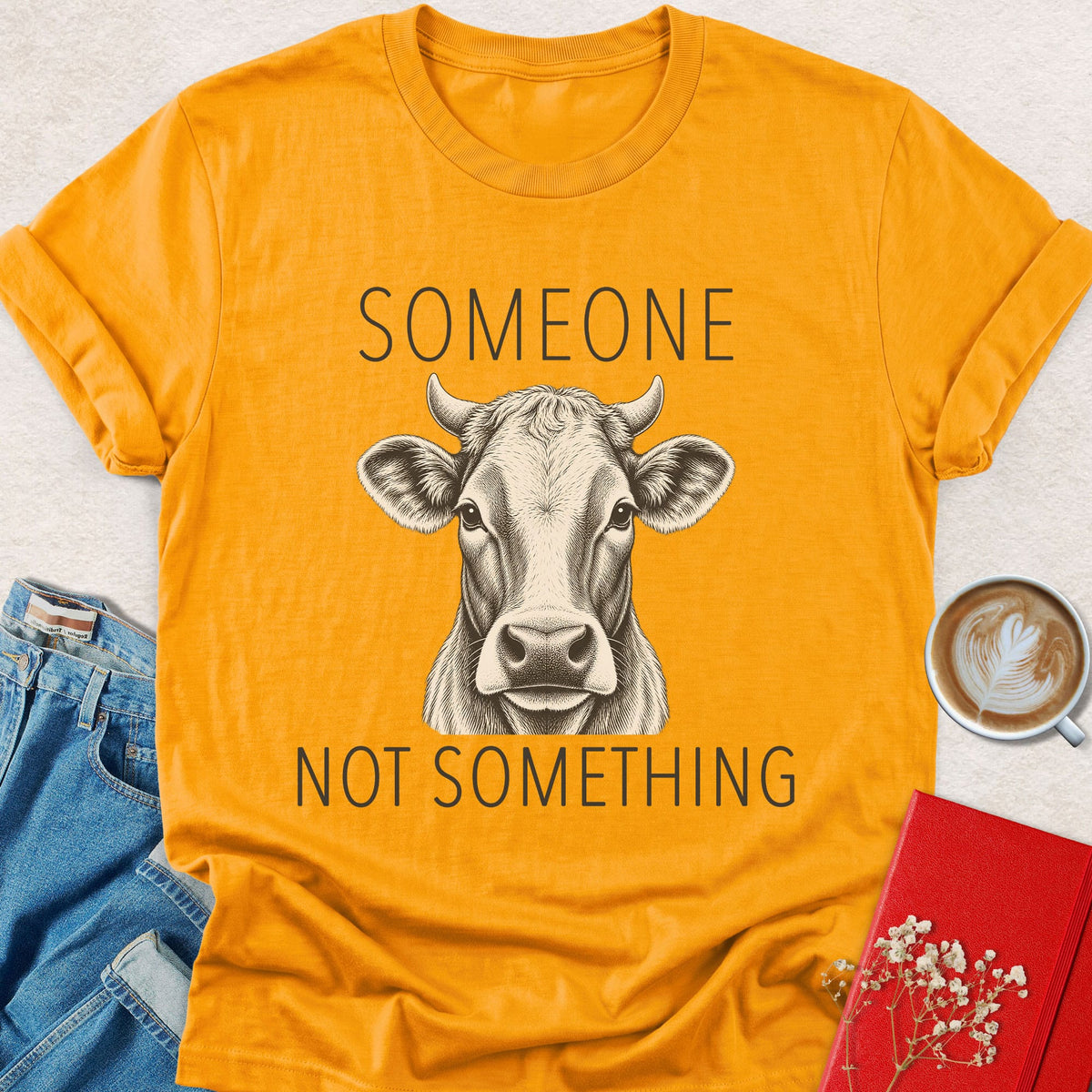 Orange cow graphic T-shirt with “Someone” and “Not something” text