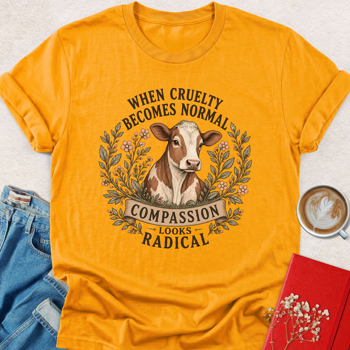 Gold cow graphic T-shirt with Compassion Looks Radical slogan