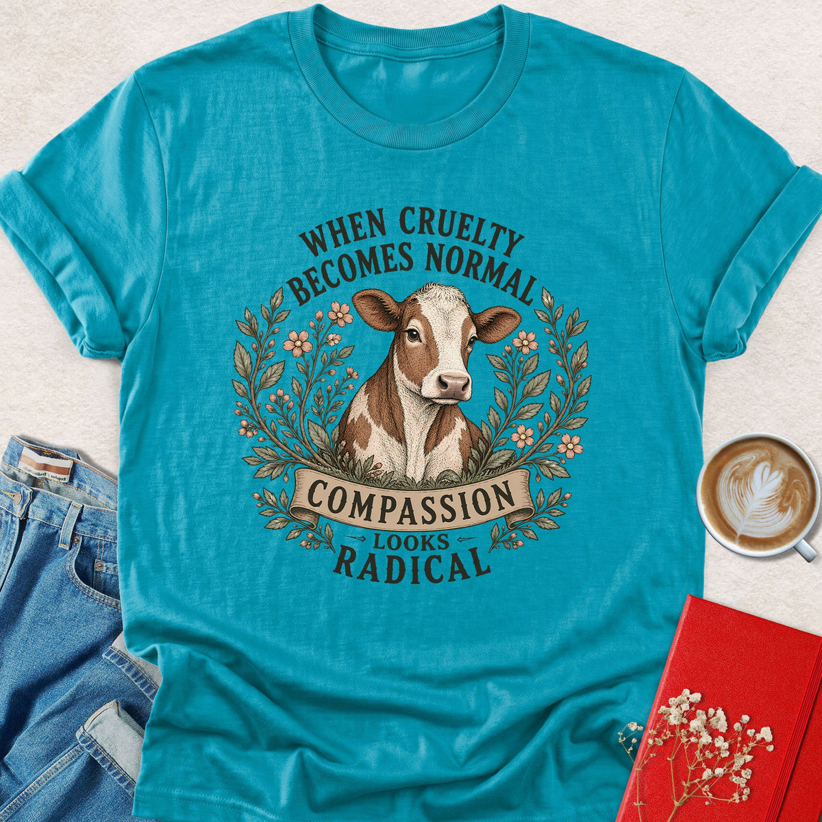 Turquoise cow graphic T-shirt with Compassion Looks Radical slogan