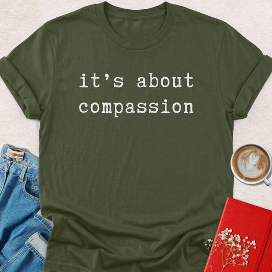 Olive green unisex t-shirt with crew neck and white 'it's about compassion' text print.