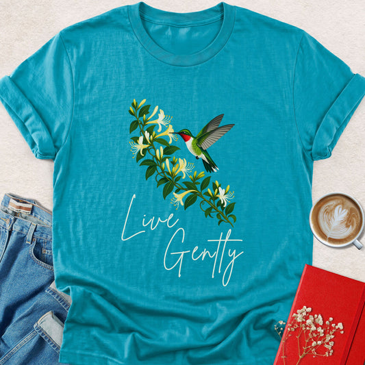 Tropical blue T-shirt with hummingbird, leafy bouquet graphic, and “Live Gently” script print
