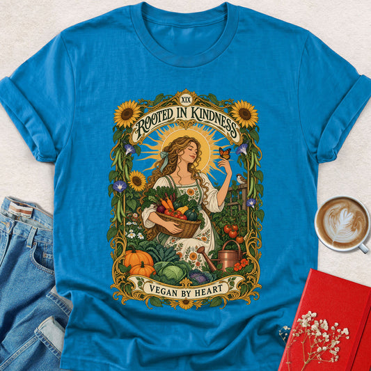 Bright blue crew-neck t-shirt with colorful “Rooted in Kindness” floral portrait graphic.