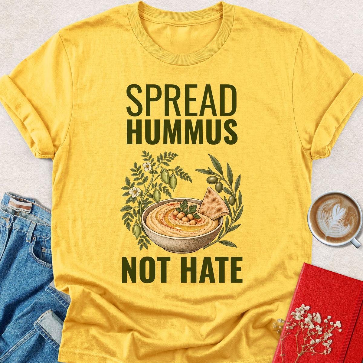 Yellow crewneck T-shirt with 'SPREAD HUMMUS'/'NOT HATE' slogan and hummus graphic.