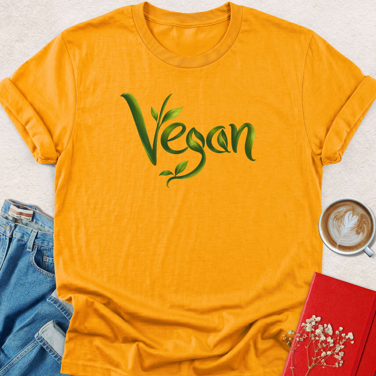Gold crewneck T-shirt with green vegan leaf script graphic