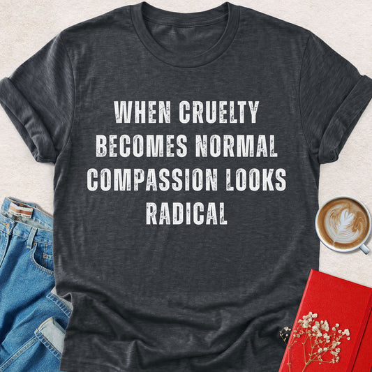 Dark gray crewneck t-shirt with white text: When cruelty becomes normal compassion looks radical