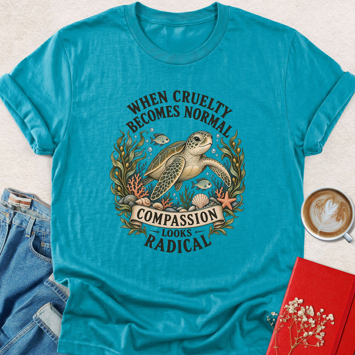 Teal crewneck sea turtle graphic T-shirt, 'Compassion looks radical' print